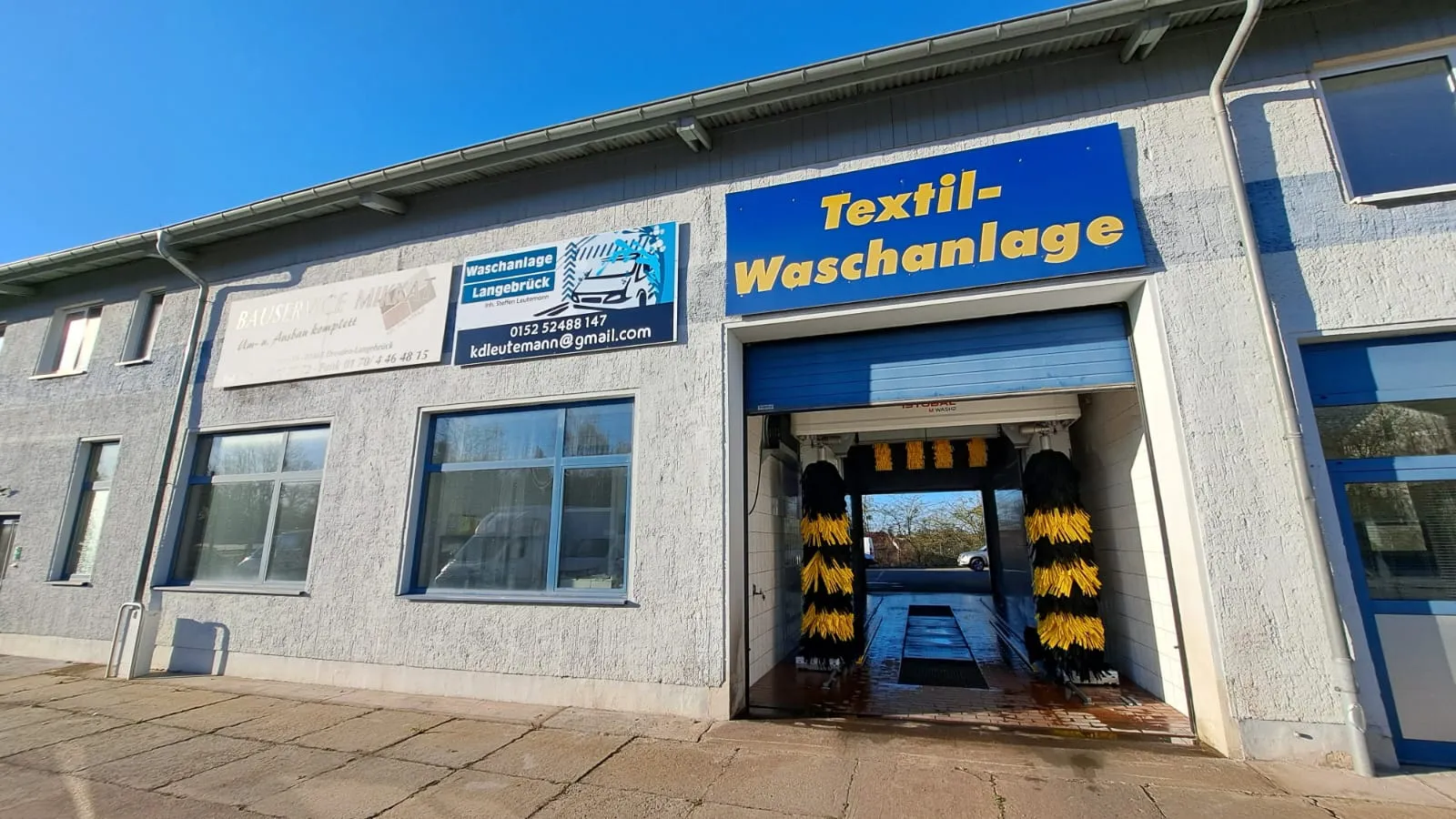 Außenansicht der Waschanlage Langebrück an der Lessingstraße 8a mit Zufahrt und Beschilderung